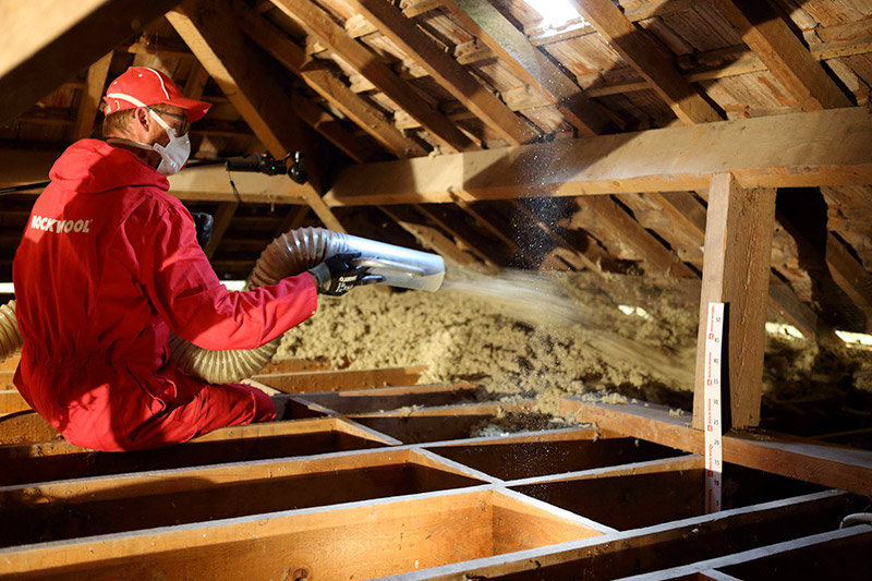 Projection de la laine de roche Rockwool dans des combles