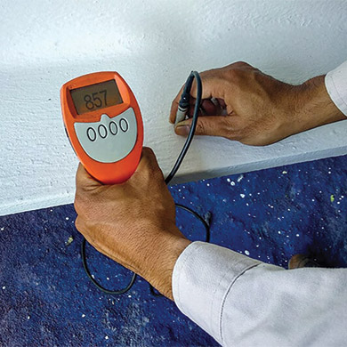 Un homme qui calcule le taux d'humidité d'un mur